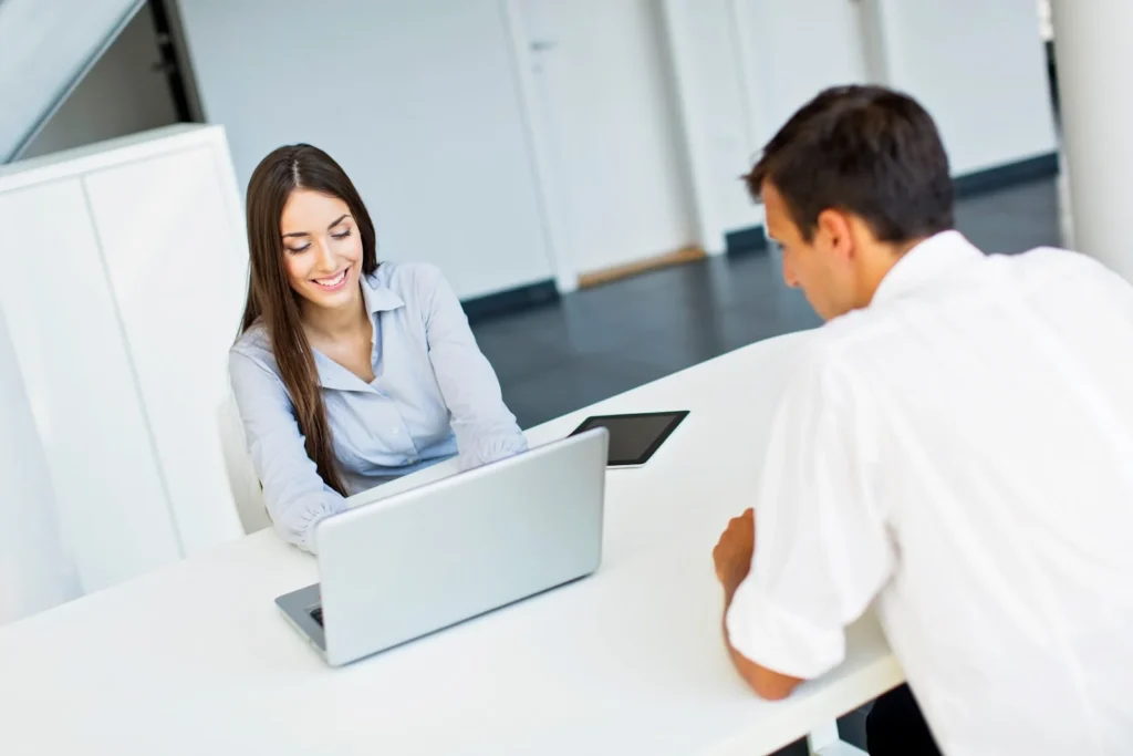 woman showing laptop screen to customer