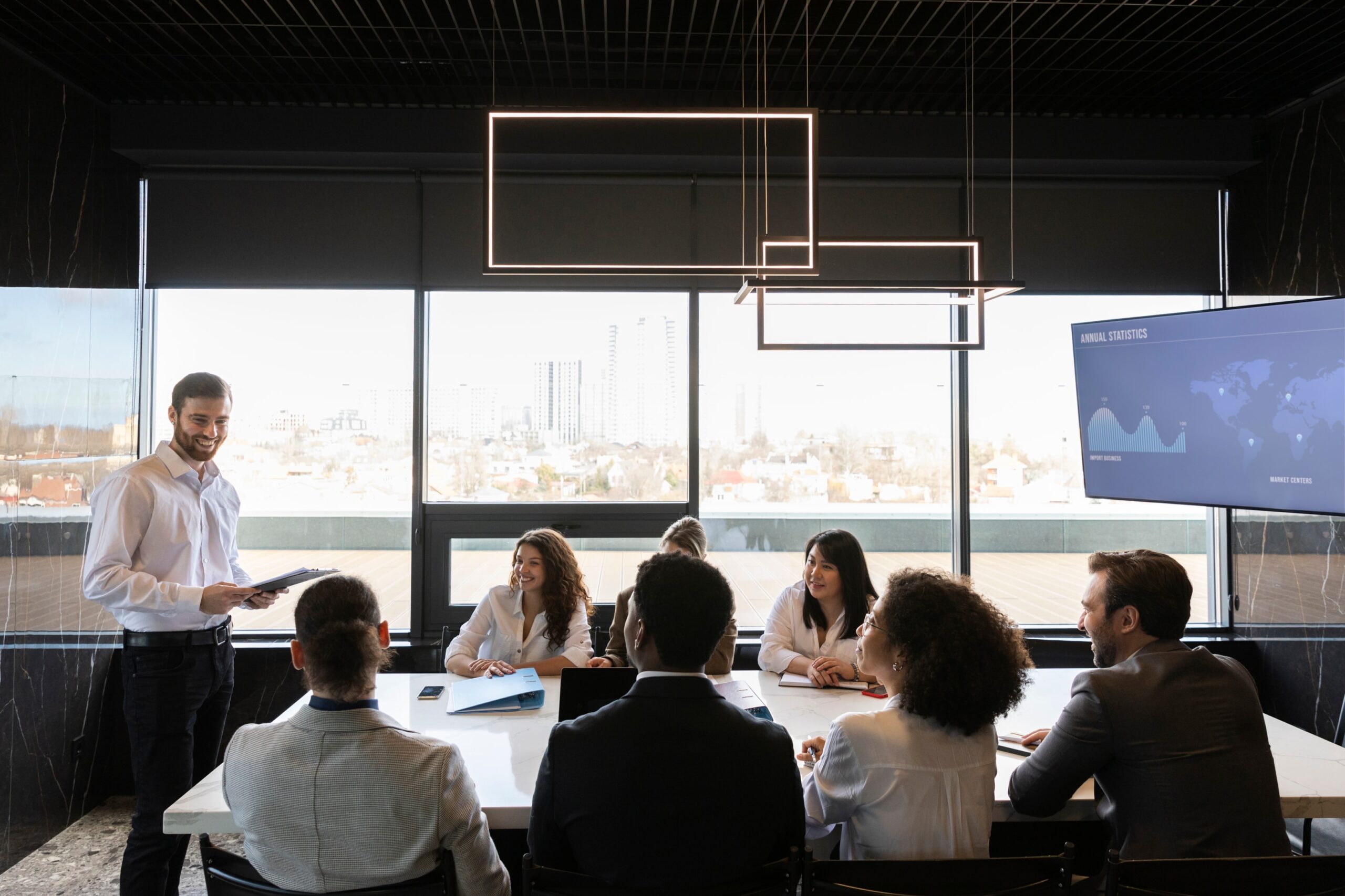 A man stands in front of a group in a conference room