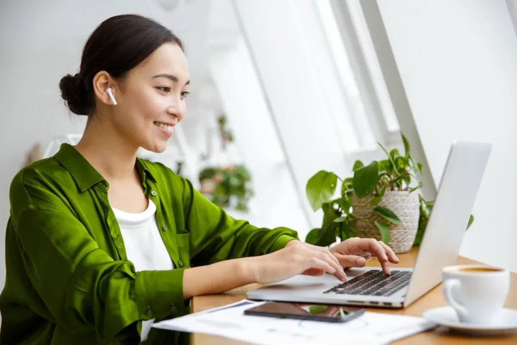 woman laughing infront of laptop